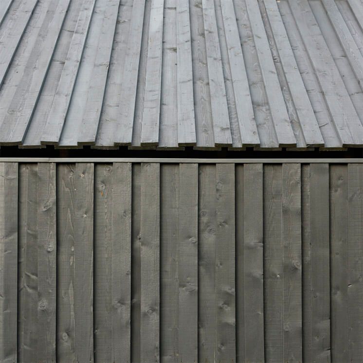 Black board-on-board timber cladding on contemporary UK house — vertical profile exterior
