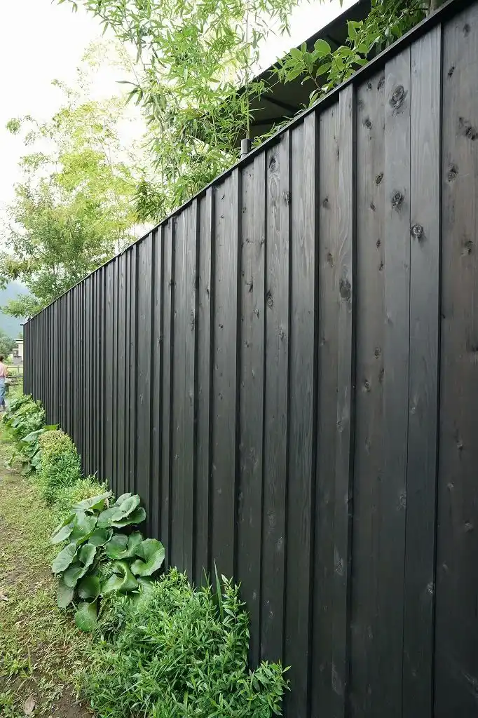 Black timber fencing panels UK — charred black fence boards contemporary garden