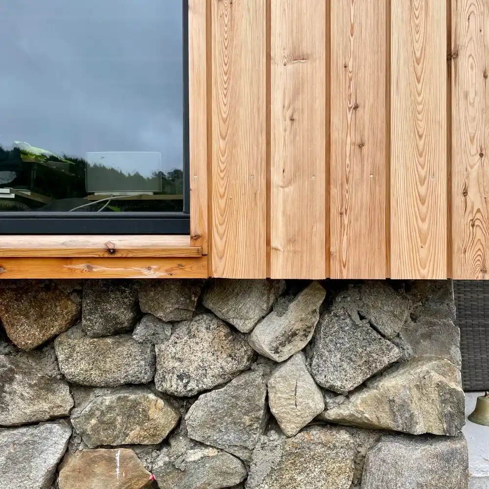 Douglas fir vertical shadow gap cladding on UK building — warm reddish-brown timber exterior