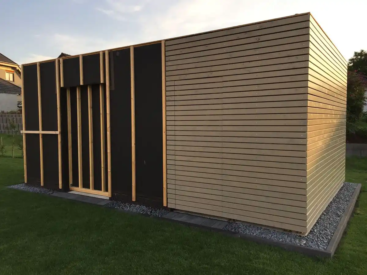 Garden room cladding installation in progress UK — timber boards being fixed to batten framework