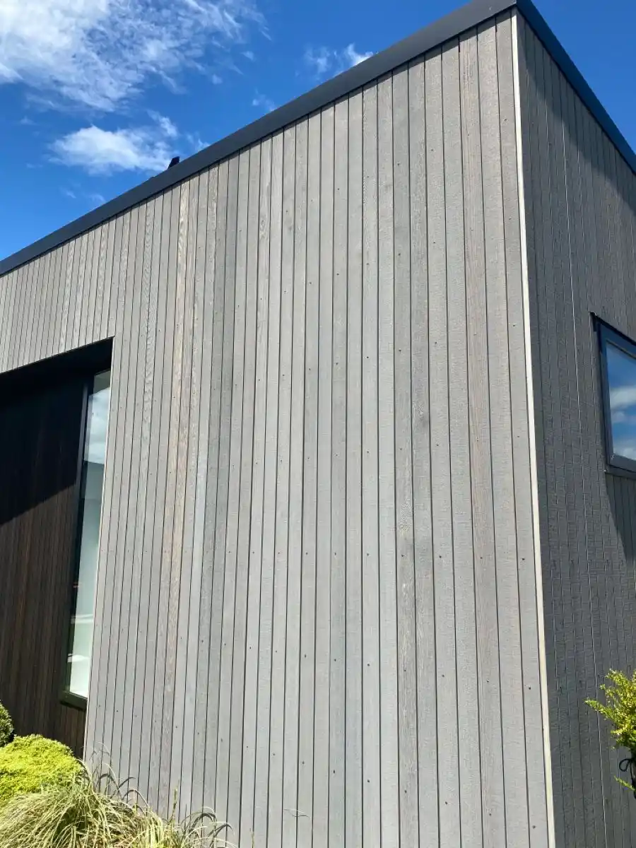 Naturally weathered timber cladding on UK garden room — silver-grey patina aged exterior
