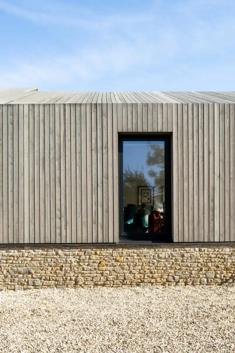 Weathered timber cladding on UK house — natural silver-grey patina exterior facade